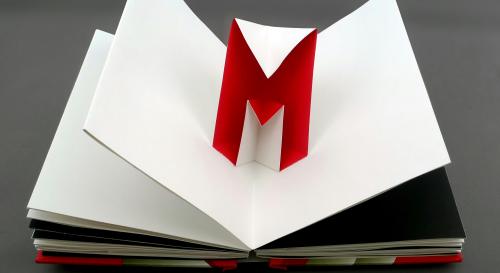 An open book with a pop up 'M' in red