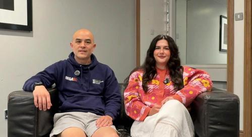 Andy Hom and Susy Williams sat on a sofa having a conversation