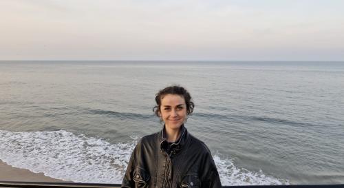 Alice Finden on the beach wearing a leather jacket