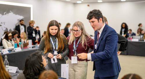three people standing up involved in discussion