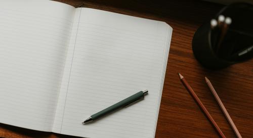 a notebook with a pen laying on top